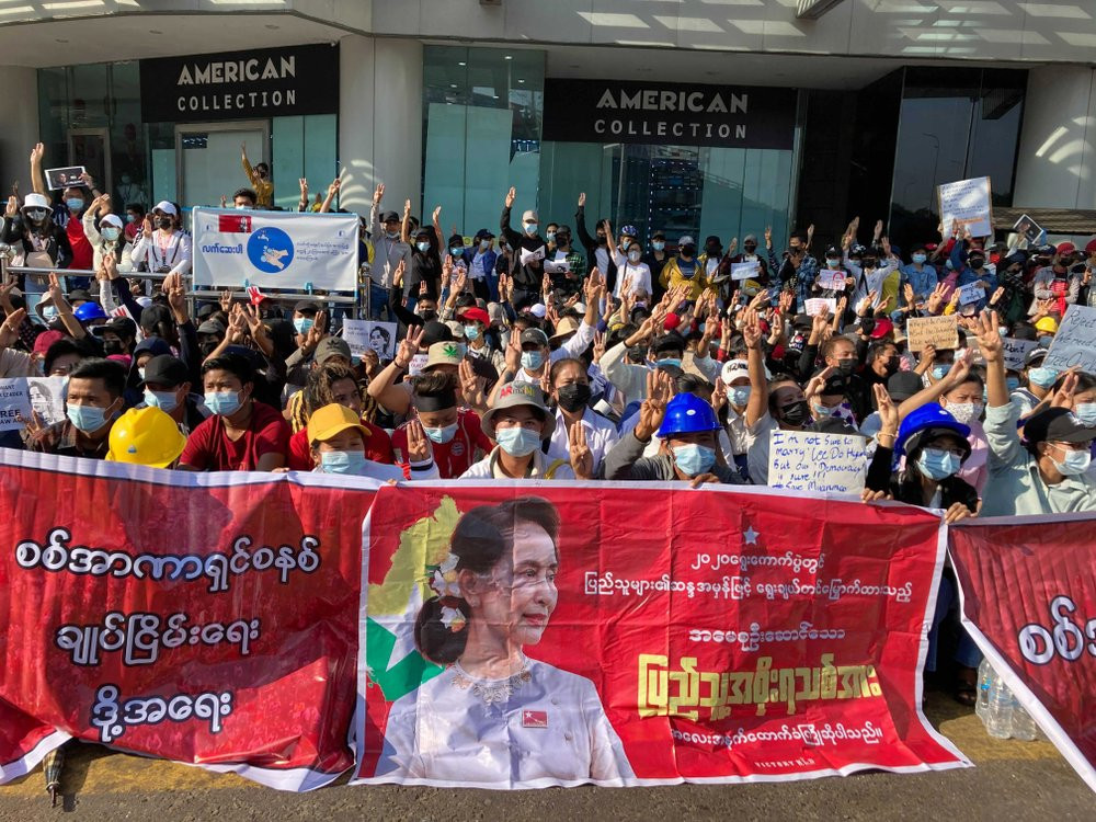 Demonstrators display three-fingered salute, a symbol of resistance at an intersection in Yangon, Myanmar Wednesday, Feb. 10, 2021.