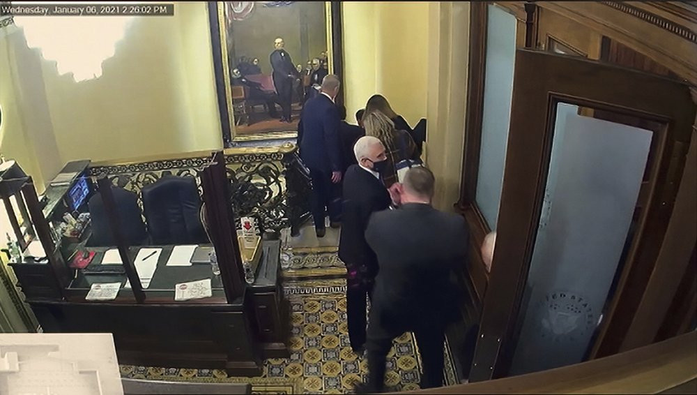 In this image from a security video showed during the second impeachment trial of former US President Donald Trump,  Vice President Mike Pence is evacuated as rioters breach the Capitol.
