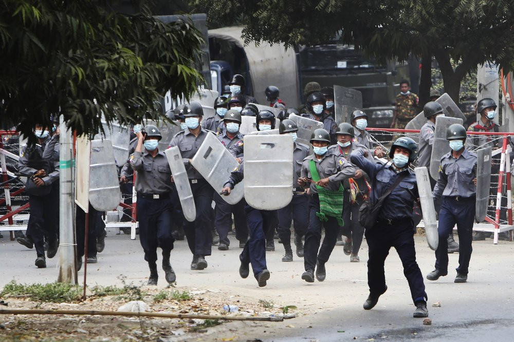 Police charge forward to disperse protesters in Mandalay, Myanmar on Saturday, Feb. 20, 2021.