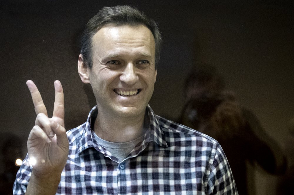 Russian opposition leader Alexei Navalny gestures as he stands behind a grass of the cage in the Babuskinsky District Court in Moscow, Russia, Saturday, Feb. 20, 2021.
