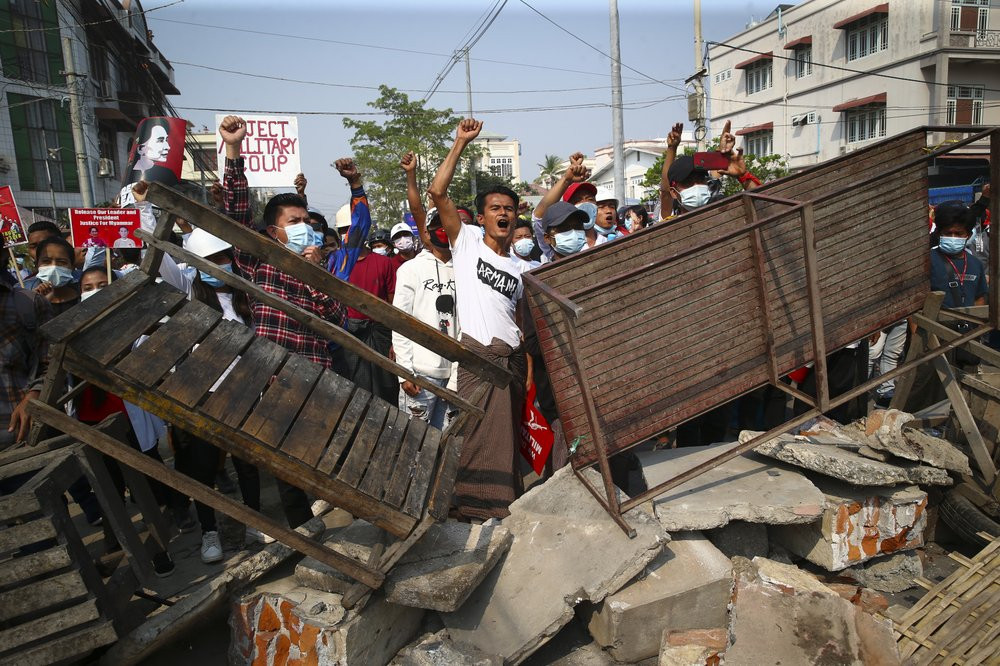 Protesters shout slogans as police arrive during a protest against the military coup in Mandalay, Myanmar, Sunday, Feb. 28, 2021.