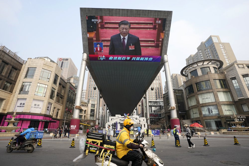 Chinese President Xi Jinping is seen on a big screen during a live broadcast of the closing session of the National People's Congress in Beijing on Thursday, March 11, 2021.