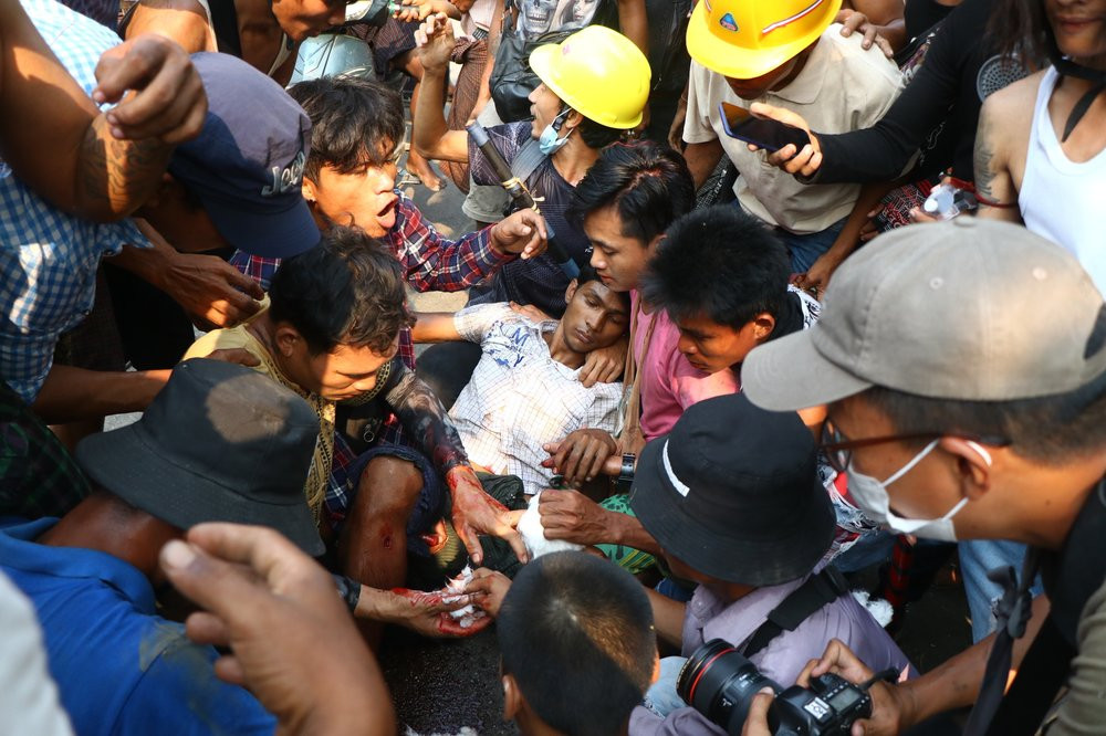 Anti-coup protesters surround an injured man in Hlaing Thar Yartownship in Yangon, Myanmar Sunday, March 14, 2021.