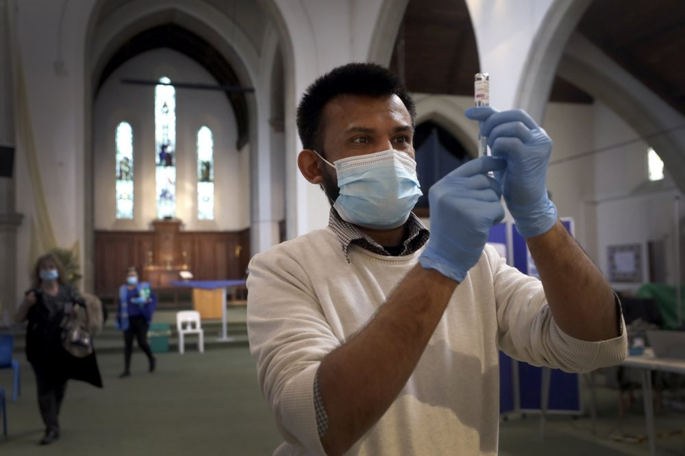 Pharmacist Rajan Shah prepares a syringe of the AstraZeneca vaccine at St John's Church, in Ealing, London, Tuesday, March 16, 2021.