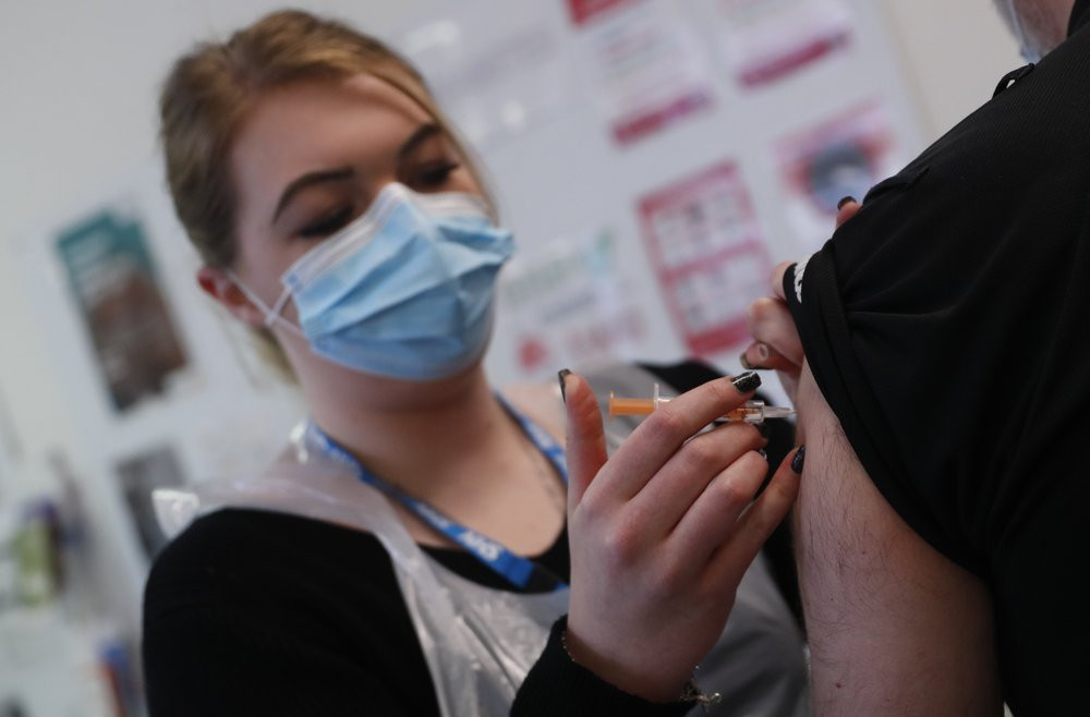 Pharmacy Technician Katrina Bonwick administers a dose of the AstraZeneca COVID-19 vaccine at the Wheatfield surgery in Luton, England, Thursday, March 18, 2021.