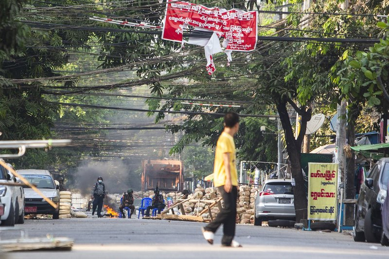 Police and military forces occupy a road block barricade in Yangon, Myanmar, Friday, March 19, 2021.