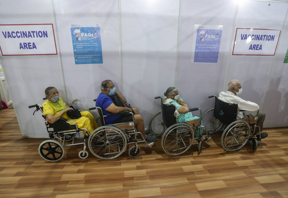 Elderly Indians on wheel chairs wait in a queue to receive COVID-19 vaccine in Mumbai, India, Monday, March 8, 2021.