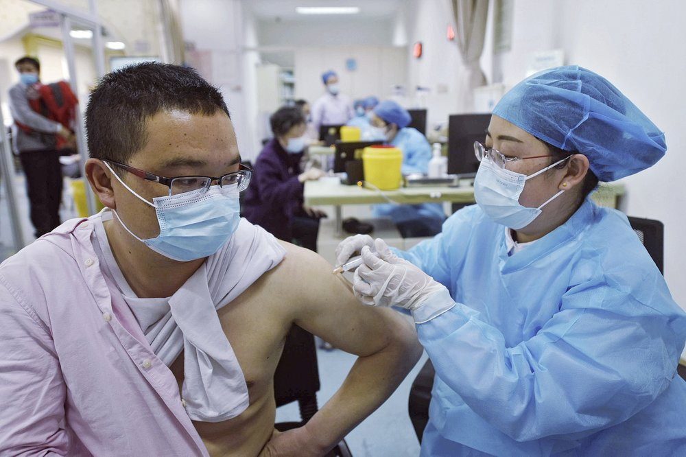 A man wearing a face mask to help curb the spread of the coronavirus receives a shot of Sinovac COVID-19 vaccine at a community health center in Hangzhou in east China's Zhejiang province on 