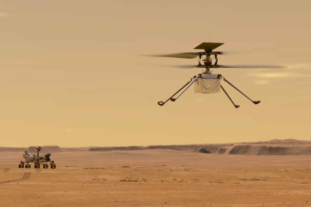 This illustration made available by NASA depicts the Ingenuity helicopter on Mars which was attached to the bottom of the Perseverance rover, background left. It will be the first aircraft to