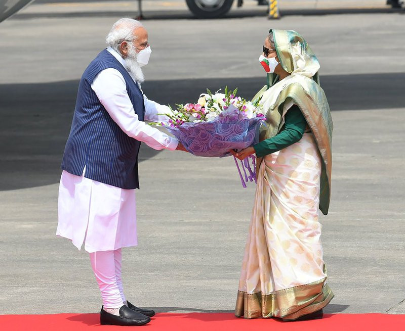n this photo provided by Prime Minister of India Narendra Modi's twitter handle, Indian Prime Minister Narendra Modi receives a bouquet of flowers from Bangladesh's Prime Minister Sheikh Hasi