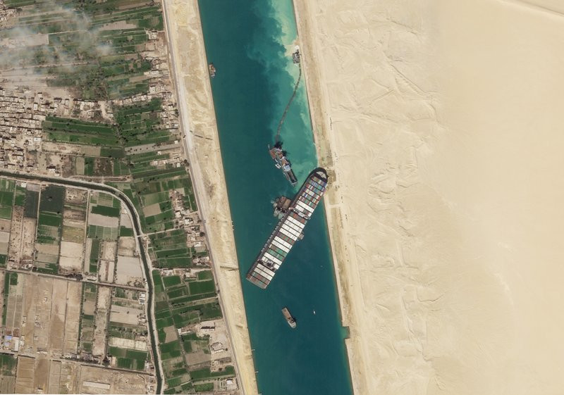 In this March 28, 2021, satellite file image from Planet Labs Inc, the cargo ship MV Ever Given sits stuck in the Suez Canal near Suez, Egypt.