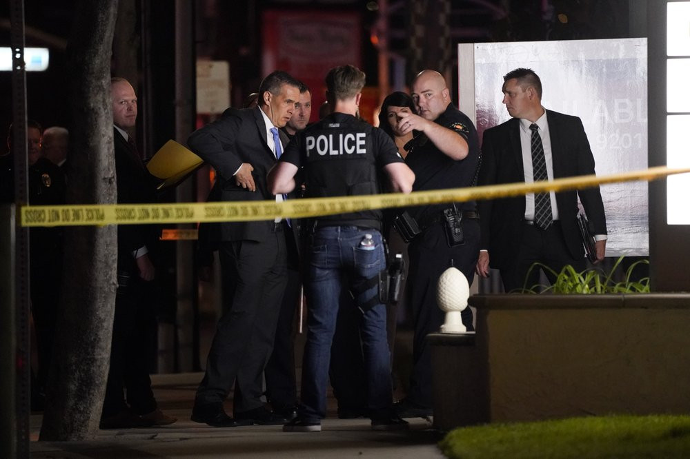 Investigators gather outside an office building where a shooting occurred in Orange, Calif., Wednesday, March 31, 2021.