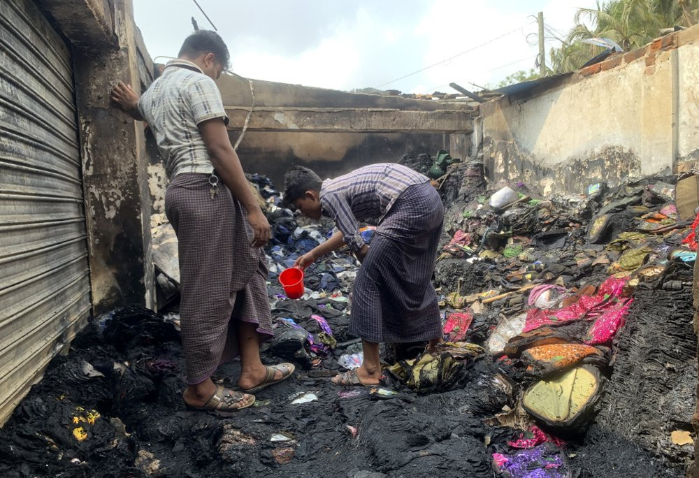People inspect the debris after a fire in a makeshift market near a Rohingya refugee camp in Kutupalong, Bangladesh, Friday, April 2, 2021.