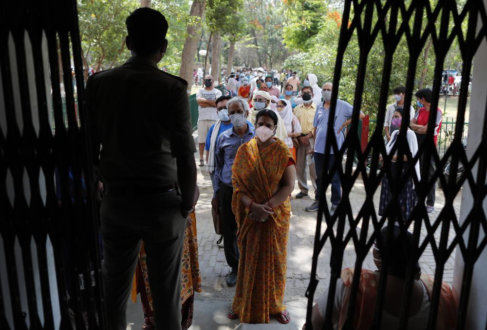 Indians line up to receive the vaccine for COVID-19 at a medical college in Prayagraj, India, Saturday, May 8, 2021.