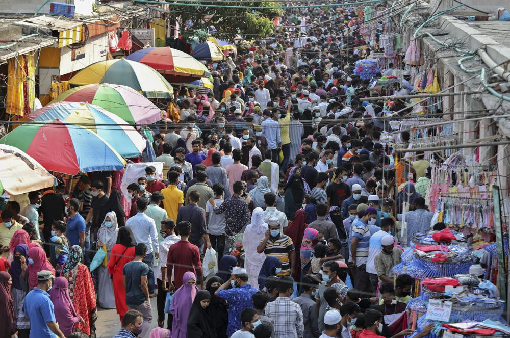 Shoppers crowd at a marketplace in Dhaka, Bangladesh, Friday, May 7, 2021. India's surge in coronavirus cases is having a dangerous effect on neighboring Bangladesh.