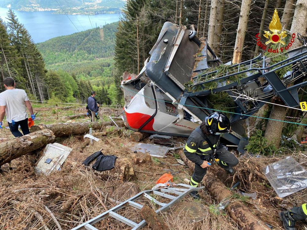 Rescuers work by the wreckage of a cable car after it collapsed near the summit of the Stresa-Mottarone line in the Piedmont region, northern Italy, Sunday, May 23, 2021.