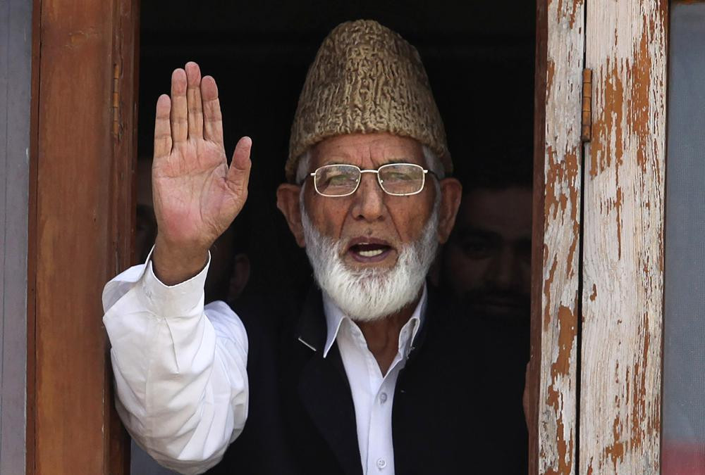 In this Wednesday, Sept. 8, 2010, file photo, Kashmiri separatist leader Syed Ali Shah Geelani waves to the media before his arrest in Srinagar, India.