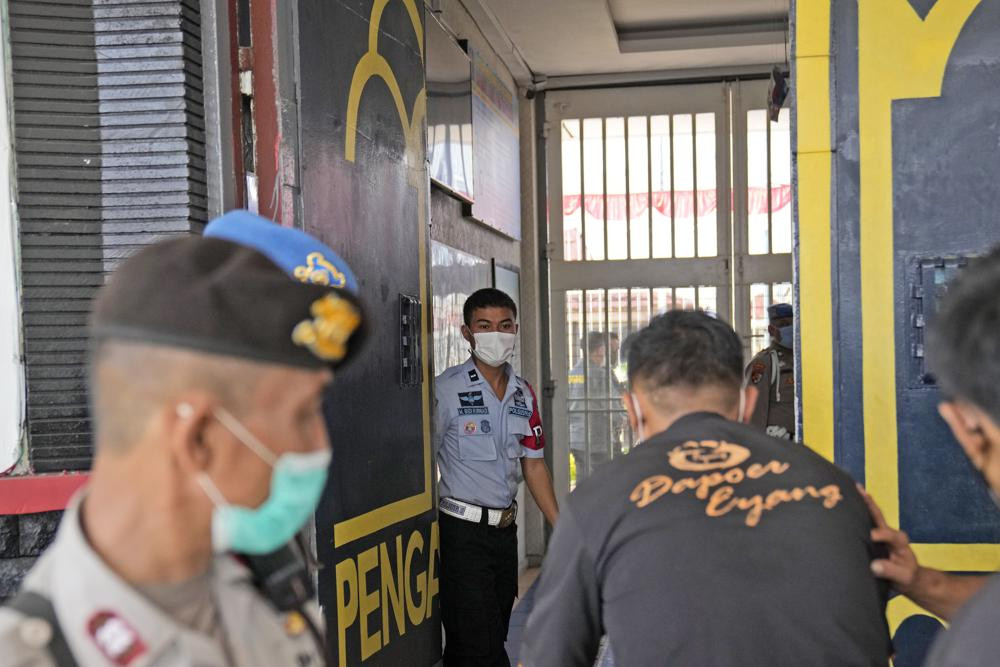 Staff and police officers guard the main entrance gate of Tangerang prison in Tangerang on the outskirts of Jakarta, Indonesia, Wednesday, Sept. 8, 2021.