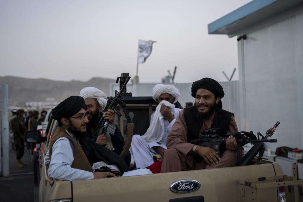 Taliban fighters sit in a pickup truck at the airport in Kabul, Afghanistan, Thursday, Sept. 9, 2021.