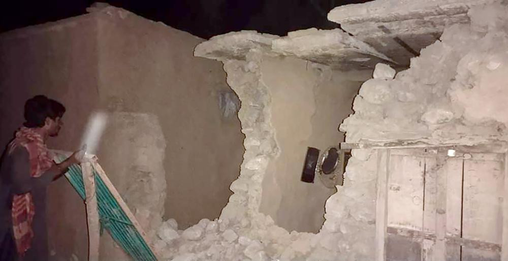 A local resident looks his damaged house following a severe earthquake hit the area, in Harnai, about 100 kilometers (60 miles) from Quetta, Pakistan, Thursday, Pakistan.