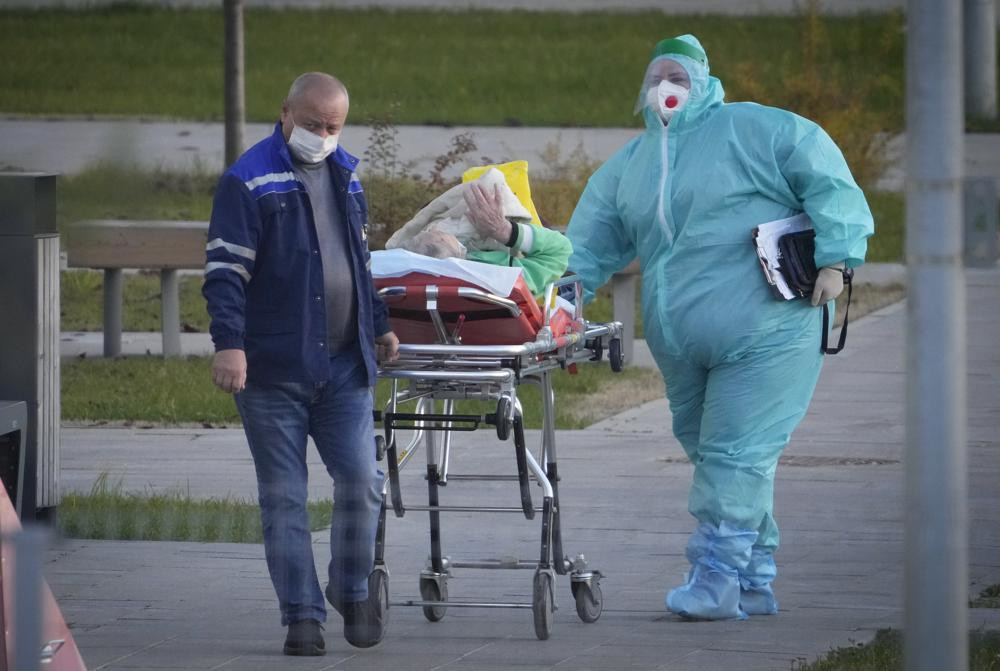 Medical workers carry a patient suspected of having coronavirus on a stretcher at a hospital in Kommunarka, outside Moscow, Russia, Monday, Oct. 11, 2021.