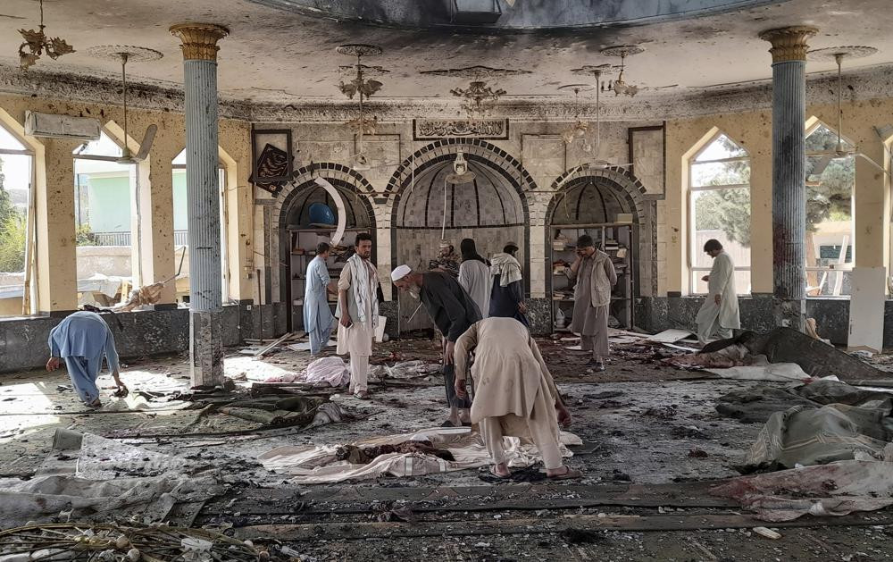 In this Oct. 8, 2021 file photo, people view the damage inside of a mosque frequented by the Shiite Muslim minority following a deadly bombing claimed by the Islamic State that killed dozens,