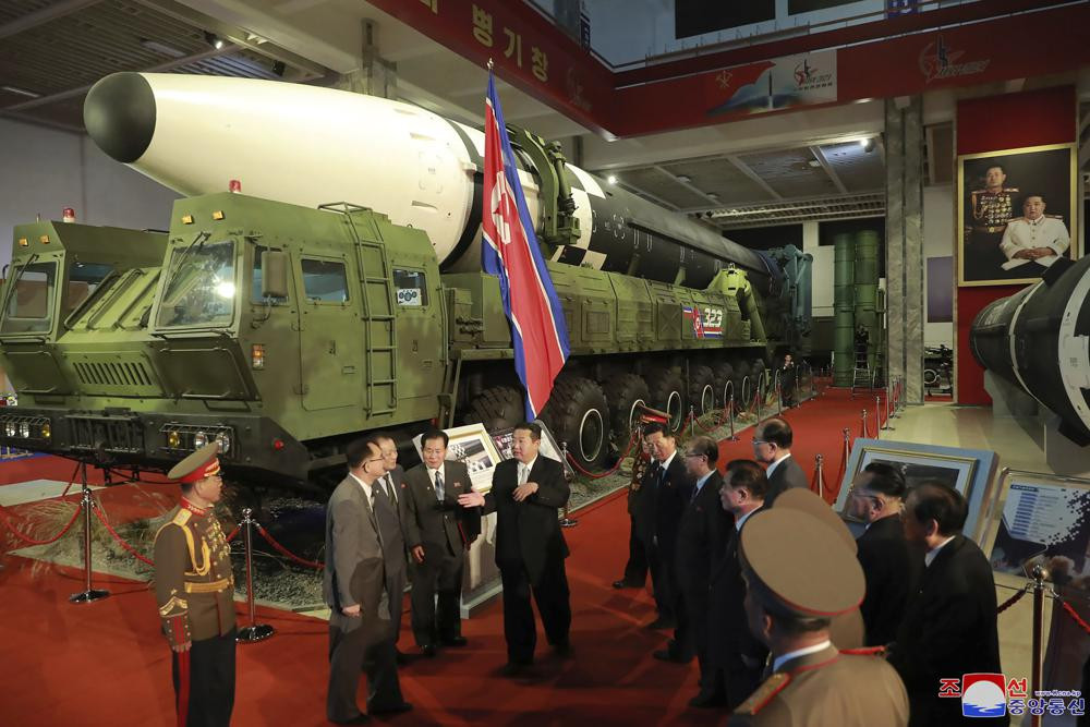 In this photo provided by the North Korean government, North Korean leader Kim Jong Un, center, speaks in front of what the North says an intercontinental ballistic missile displayed at an ex