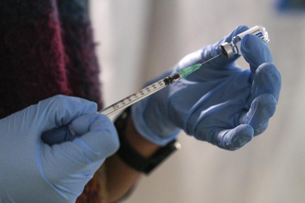 A staff member from the National Health Organisation (EODY) prepares a booster Johnson and Johnson vaccine against COVID-19 at Karatepe refugee camp, on the northeastern Aegean island of Lesb