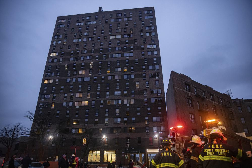 Emergency personnel work at the scene of a fatal fire at an apartment building in the Bronx on Sunday, Jan. 9, 2022, in New York.