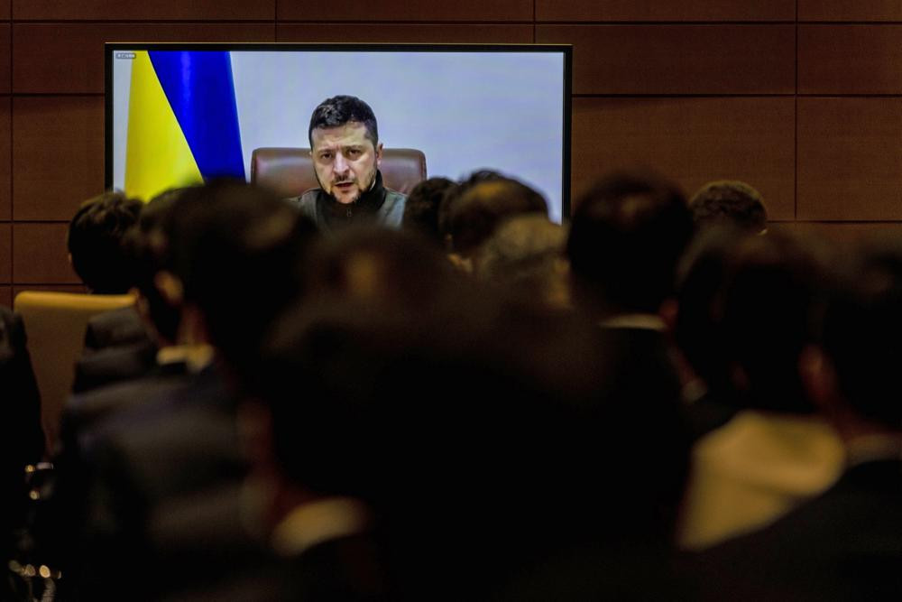 Members of Japan's lower house of parliament applaud as Ukrainian President Volodymyr Zelenskyy delivers a virtual address to Japanese lawmakers in Tokyo, Wednesday, March 23, 2022.