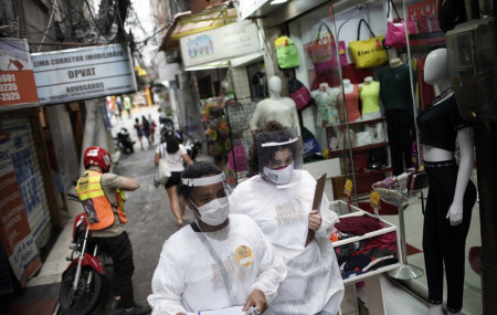 Health workers walk through the Rocinha slum to test people for COVID-19 as part of a rapid test campaign by the civilian organization "Bora Testar," or "Let's Test" in Rio de Janeiro, Brazil