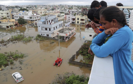 Residents look at a street inundated with floodwater after heavy rainfall in Hyderabad, India, India, Wednesday, Oct. 14, 2020.