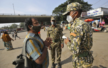 A man pleads with municipal officers as he is fined for not wearing a face mask in Bengaluru, India, Thursday, Oct. 29, 2020.