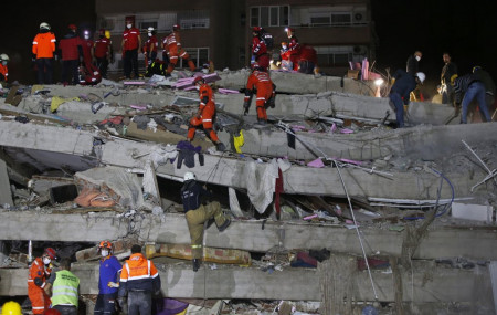 Members of rescue services search in the debris of a collapsed building for survivors in Izmir, Turkey, early Saturday, Oct. 31, 2020.