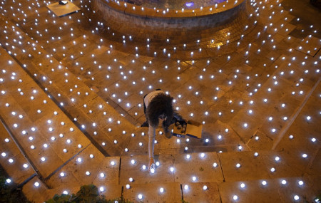 An activist turns on LED candles at a memorial for Israel's victims of COVID-19, in Jerusalem, Sunday, Nov. 8, 2020.