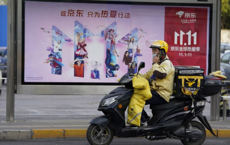 A delivery man passes by an ad for the Nov. 11 Sales Day in Beijing, China on Oct. 28, 2020.