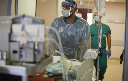 Doctors carry a coronavirus patient in the Intensive Care Unit at Varese’s Circolo hospital, in Varese, Italy, Friday, Nov. 6, 2020.