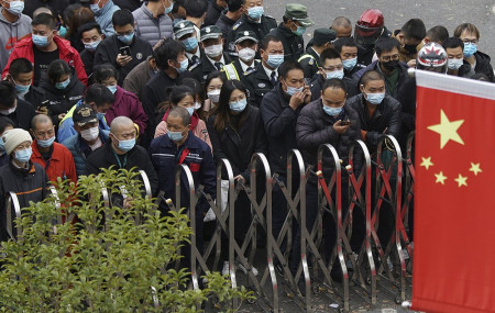 Airport workers wearing face masks to help curb the spread of the coronavirus wait for COVID-19 testing at the Shanghai Pudong International Airport in Shanghai, Monday, Nov. 23, 2020.