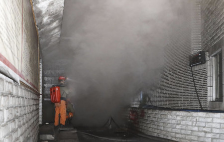 In this photo released by Xinhua News Agency, rescue workers gauge the density of carbon monoxide in the smog at the entrance of the coal mine in Yongchuan District of Chongqing, southwestern