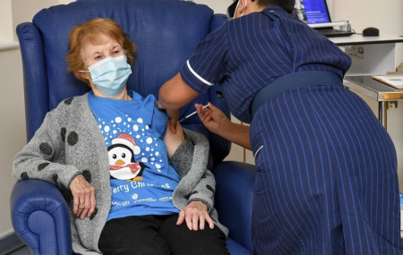 90 year old Margaret Keenan, the first patient in the UK to receive the Pfizer-BioNTech COVID-19 vaccine, administered by nurse May Parsons at University Hospital, Coventry, England, Tuesday 