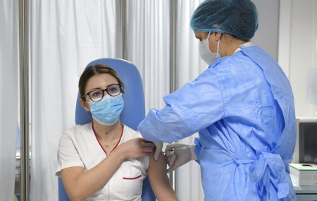 Mihaela Anghel, a Romanian nurse, gets the first COVID-19 vaccine administered in the country in Bucharest, Romania, Sunday, Dec. 27, 2020.