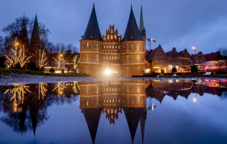 The medieval Holstentor is reflected in water in Luebeck, Germany, Monday, Jan. 4, 2021. The German government will decide about further restrictions to avoid the outspread of coronavirus on 