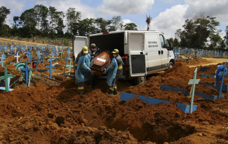 In this Jan. 6, 2021, file photo, cemetery workers carry the remains of 89-year-old Abilio Ribeiro, who died of the coronavirus, to bury at the Nossa Senhora Aparecida cemetery in Manaus, Ama