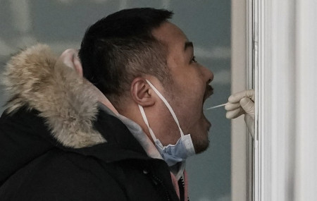 A man gets a swab for the coronavirus test at a hospital in Beijing, Sunday, Jan. 17, 2021.