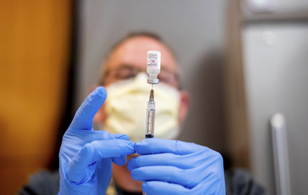 In this Jan. 12, 2021, file photo a pharmacist draws saline while preparing a dose of Pfizer's COVID-19 vaccine in Sacramento, California.