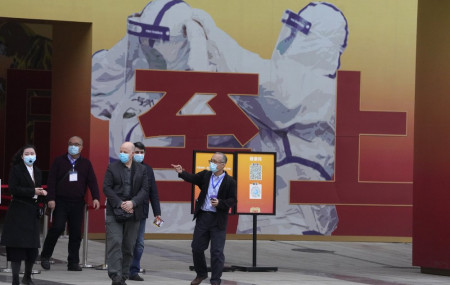 In this Jan. 30, 2021, file photo, members of the WHO team including Ken Maeda, center, Peter Daszak, third from left and Vladmir Dedkov, fourth from left, leave after attending an exhibition