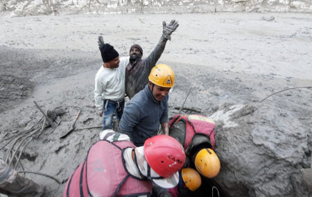 This photograph provided by Indo Tibetan Border Police (ITBP) shows a man reacting after he was pulled out from beneath the ground by ITBP personnel during rescue operations after a portion o