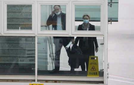 Peter Ben Embarek and Thea Koelsen Fischer of the World Health Organization team prepares to board a plane from the tarmac at the airport to leave at the end of the WHO mission in Wuhan, Chin