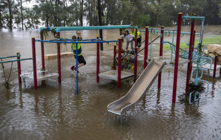 People play on equipment at a playground on the banks of the Nepean River at Jamisontown on the western outskirts of Sydney Monday, March 22, 2021.