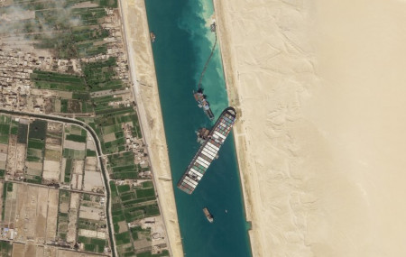 In this March 28, 2021, satellite file image from Planet Labs Inc, the cargo ship MV Ever Given sits stuck in the Suez Canal near Suez, Egypt.